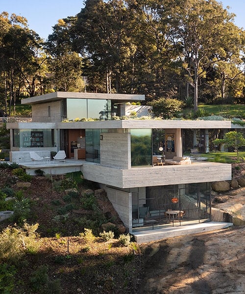 bunkeren house: half-buried volumes integrate into sloping rocky site in australian village